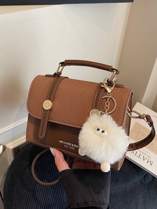 Vintage brown leather crossbody bag with top handle and plush charm accessory