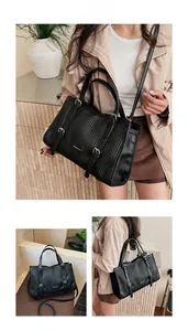 Detail of black PU leather tote bag with vertical stripes and metallic buckle decor