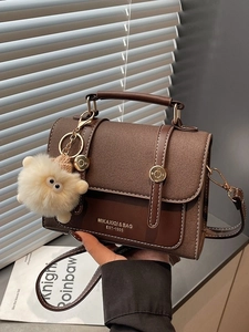 Chic vintage brown crossbody bag with handle and plush charm for women's fashion