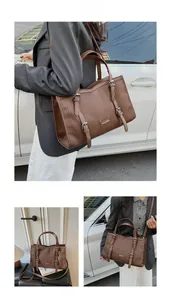 Detail view of large brown pleated tote bag with metal buckles and FASHION brand plate