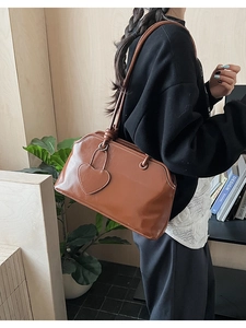 Detailed view of a brown vintage leather tote with heart charm in a lifestyle setting