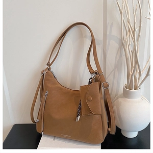 Detail of caramel leather tote bag showing fine texture and branded silver hardware