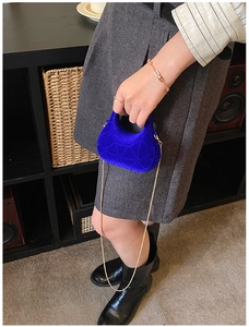 Detail of royal blue velvet handbag with quilted geometry and gold chain strap