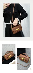 Detailed view of brown vintage leather crossbody bag with iconic gold H-shaped clasp