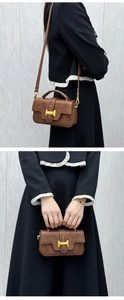 Detail of a brown vintage leather tote with a gold H buckle and slim shoulder strap