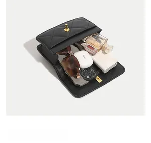 Detail showing internal capacity of the black quilted crossbody bag with daily essentials