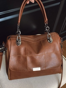 Brown quilted Boston handbag with chain strap and adjustable leather shoulder handle