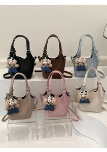 Close-up of diverse mini bucket bags with cute bear charms on a tiered stand