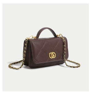 Detailed view of dark brown litchi grain leather bag with quilted pattern and gold lock
