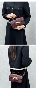 Detail of vintage burgundy leather handbag featuring a gold buckle and dual-wear strap