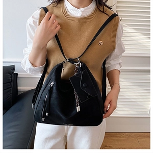 Detailed view of the large black hobo bag with silver zipper and tassel accessory