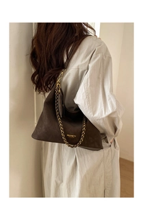 Detail of a large brown suede tote bag with metal chain and leather shoulder straps