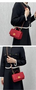 Detail view of red quilted leather crossbody bag with golden interlocking rings