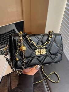 Sac bandoulière matelassé noir brillant avec chaîne dorée et charm boule dorée