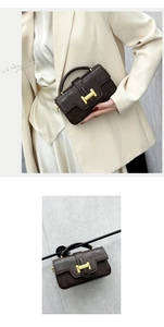 Detail view of deep brown vintage handbag with gold H-shaped clasp and single top handle