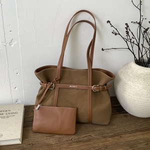 Detail of brown matte tote bag with leather buckle strap and small matching pouch