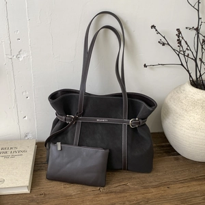 Detail view of deep brown tote bag set with metal buckle and small zipper pouch