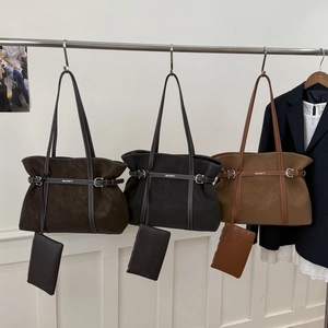 Detailed view of large tote bags in three colors with matching pouches on a hanger