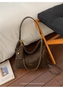 Detail of dark brown matte tote bag featuring woven chain strap and matching coin purse