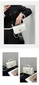 Detailed view of white quilted leather bag with gold chain strap and interlocking metal clasp