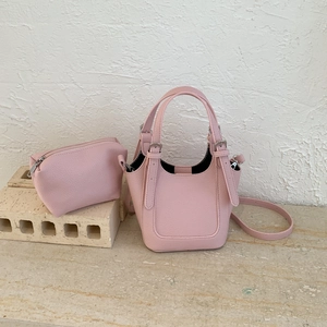 Detail of light pink bucket bag set with pebble grain leather and small pouch