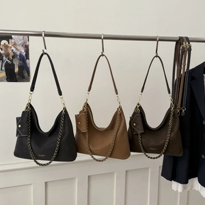 Detailed set of three suede hobo tote bags in black, camel, and brown with gold logo