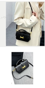 Close-up of vintage black litchi leather handbag featuring a golden H-buckle hardware