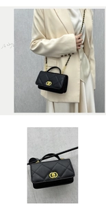 Detail of black quilted leather crossbody bag with gold metal handle and chain strap