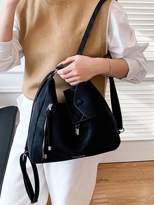Large black leather tote bag with side zipper detail and a matching mini envelope pouch