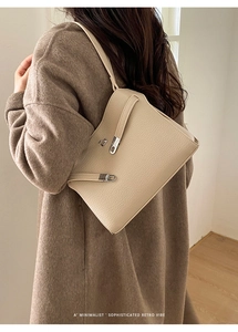 Détail du sac bandoulière crème en cuir grainé avec un fermoir métallique argenté élégant