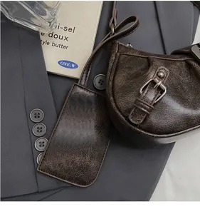 Detail of dark brown vintage crackle leather mini pouch and card holder with buckle