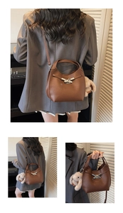 Detail of brown litchi grain leather bucket bag with silver bow buckle and rabbit charm