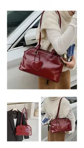 Detail of burgundy vintage tote bag with glossy leather texture and heart charm