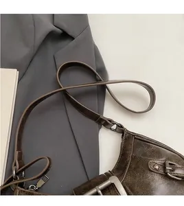 Detailed view of brown vintage distressed leather bag with silver studs and metal hardware