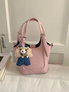 Pink lychee grain leather bucket bag with cute puppy plush charm and adjustable strap