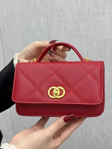 Red quilted leather mini handbag with gold clasp and top handle in a minimalist style