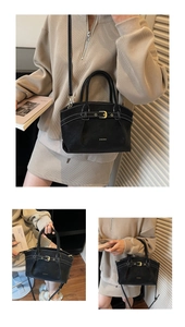 Close-up of black matte handbag with gold buckle, leather straps, and brand logo detail