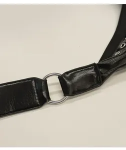 Détail de la bandoulière en cuir noir brillant et de la boucle en métal argenté du sac