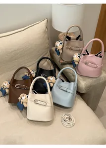 Detailed macro view showing six colorful textured bucket bags with bear pendants
