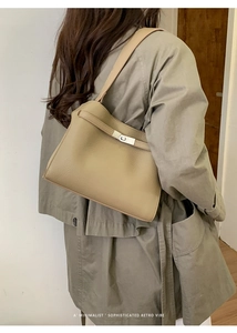 Détail d'un sac cabas minimaliste en cuir beige avec fermoir métallique porté à l'épaule