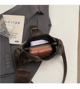Interior detail of brown vintage faux leather crossbody bag showing capacity and black lining