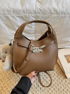 Brown vintage leather bucket bag with silver buckle and plush animal charm accessory