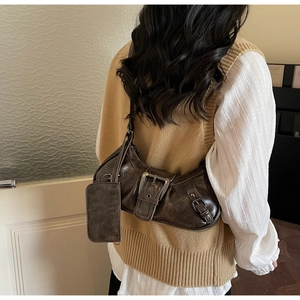 Detail of dark brown vintage motorcycle bag with metallic buckle and detachable pouch