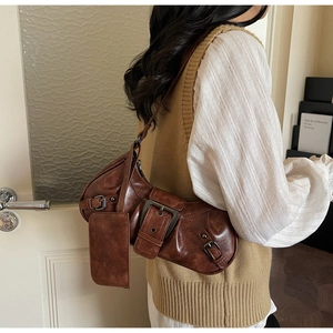 Detail of vintage brown leather bag with retro silver metal buckle and small hanging pouch