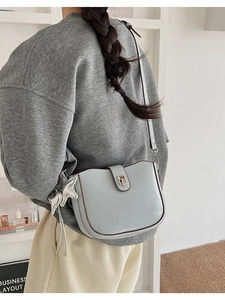 Detailed view of light blue crossbody bag with star charm and silver buckle closure