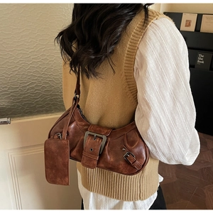 Detailed view of brown vintage baguette bag with metal buckle and mini card holder pouch