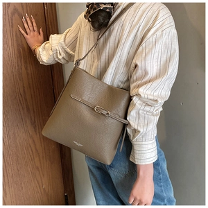 Détail du sac seau kaki montrant la texture cuir litchi et la boucle argentée