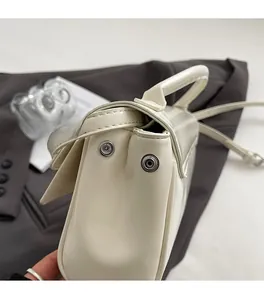 Detailed close-up of premium silver hardware and leather texture on a beige handbag