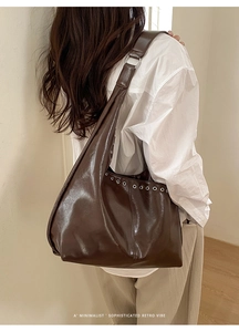 Grand sac cabas rétro marron foncé avec œillets argentés porté par un mannequin