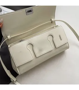 Detail view of the cream leather crossbody bag with silver twist lock and open flap cover